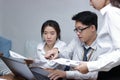 Group of young Asian business people working together on a laptop computer at office. Teamwork brainstroming concept. Selective fo Royalty Free Stock Photo