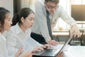 Group of young Asian business people working together on a laptop computer at office. Teamwork brainstroming concept. Selective fo Royalty Free Stock Photo