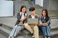 Group of young Asian college students sitting on stairs, talking and focusing on their school project Royalty Free Stock Photo