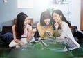 Group of young asian female friends in coffee shop,Using digital devices,chatting Royalty Free Stock Photo