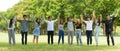 Happy young group of friends with arms raised together at the park Royalty Free Stock Photo