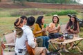 Group of young Asian friends party on vacation enjoy cheering with beer bottle. drinking at camping lake side. hands holding Royalty Free Stock Photo