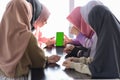 Young asian teenager sitting at cafe looking at blank phone screen together for copy space Royalty Free Stock Photo