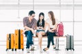 Group of young Asian travelers using smartphone checking flight or online check-in at airport together