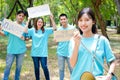 Group of young Asian volunteers holding signs supporting nature and the environment.