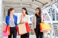 Group of young Asian women carrying shopping bags while walking along the street. Happy Life and Shopping Concepts Royalty Free Stock Photo