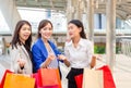 Group of young Asian women carrying shopping bags while walking along the street. Happy Life and Shopping Concepts Royalty Free Stock Photo