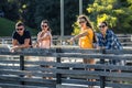 Group of young and attractive people is standing on bridge in park. Royalty Free Stock Photo