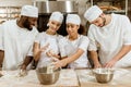 group of young baking manufacture workers kneading