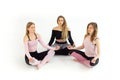 Group of young beautiful girls from three people doing yoga namaste with closed eyes. Royalty Free Stock Photo