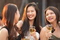 Group of young beautiful happy asian women holding glass of wine chat together with friends while celebrating dance party on Royalty Free Stock Photo