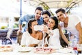 Group of young beautiful people sitting in a restaurant and taki