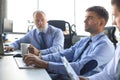 Group of young business men in formalwear working using computers while sitting in the office Royalty Free Stock Photo