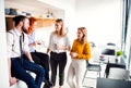 A group of young business people on coffee break in office kitchen. Royalty Free Stock Photo