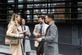 Group of young business people, job candidates standing in front of the office building waiting to be called to meeting with the Royalty Free Stock Photo