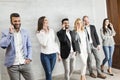 Young business people with mobile phone standing by the wall Royalty Free Stock Photo