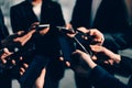 Group of young business people with smartphones standing in a circle Royalty Free Stock Photo