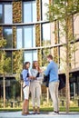 Group of young business people talking in front of a building. vertical image with copy cpace