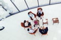 Group of young business professionals sitting together and having casual discussing in office hallway achieving goals.