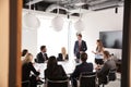 Group Of Young Businessmen And Businesswomen Meeting Around Table At Graduate Recruitment Assessment Day Royalty Free Stock Photo