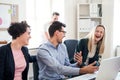 Group of young businesspeople around table in a modern office, having meeting. Royalty Free Stock Photo