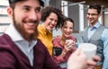 A group of young businesspeople with cup of coffee standing in office. Royalty Free Stock Photo