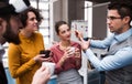 A group of young businesspeople with cup of coffee standing in office, talking. Royalty Free Stock Photo