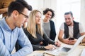 Group of young businesspeople with laptop working together in a modern office. Royalty Free Stock Photo