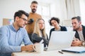 Group of young businesspeople with laptop working together in a modern office. Royalty Free Stock Photo