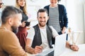 Group of young businesspeople with laptop working together in a modern office. Royalty Free Stock Photo