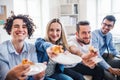 Group of young businesspeople with pizza having lunch in a modern office. Royalty Free Stock Photo