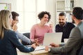 Group of young businesspeople sitting around table in a modern office, having meeting. Royalty Free Stock Photo