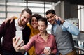 A group of young businesspeople with smartphone in office, taking selfie. Royalty Free Stock Photo