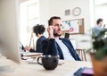 Group of young businesspeople with smartphone working together in a modern office. Royalty Free Stock Photo