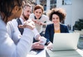 Group of young businesspeople using laptop in courtyard, start-up concept. Royalty Free Stock Photo