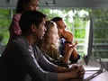 Group of young businesspersons looking intently at the screen Royalty Free Stock Photo