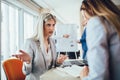 Group of young businesswomen working and communicating while sitting at the office desk together Royalty Free Stock Photo