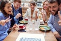 Group of young caucasian people having a video call at lunch in restaurant. fun, technology, online, internet, friends, business Royalty Free Stock Photo