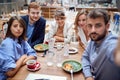 Group of young caucasian people taking selfie at lunch in restaurant. fun, selfie, friends, business partners, colleagues Royalty Free Stock Photo