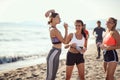 Group of young caucasian sporty adult people at the sandy beach