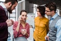 A group of young businesspeople with smartphone standing in office, making a phone call. Royalty Free Stock Photo