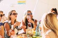 Group of young cheerful women have fun all together during lunch at home or restaurant - people celebrating in friendship with