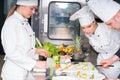 A group of young chefs prepairing meal in luxury restaurant