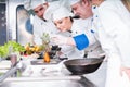 A group of young chefs prepairing meal in luxury restaurant