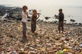 Group of young children from Banganga slum in Mumbai standing on dirty beach with a lot of rubbish