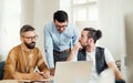 Group of young businesspeople with laptop working together in a modern office. Royalty Free Stock Photo