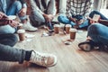 Group of a young coworkers sitting together on the floor resting during the coffee break Royalty Free Stock Photo