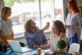 Group of young creative colleagues enjoying coffee while working in the office together