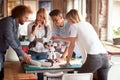 Group of young creative people is analyzing a robot toy at work in the office Royalty Free Stock Photo