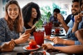 Group of young diverse people sitting at restaurant table having a meal together Royalty Free Stock Photo